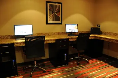 a office with three computers on a desk with chairs at Chateau Inn & Suites Bonnyville in Bonnyville