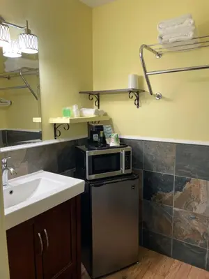 a bathroom with a sink and a microwave on a refrigerator at Port-O-Call Inn in Nanaimo