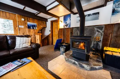 a living room with a wood burning stove at Red Shutter Inn in Rossland