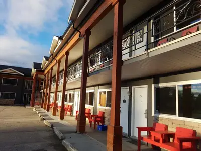 a row of red benches sitting outside of a building at Alpine Inn & Suites in Revelstoke