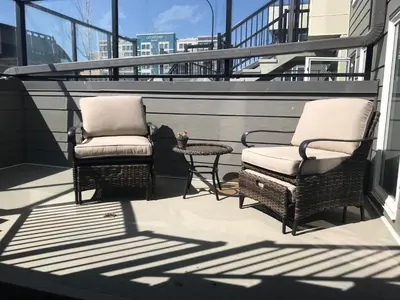 two chairs and a table on a balcony at Home Sweet Condo in Calgary
