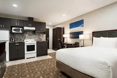 a hotel room with a bed and a kitchen at Days Inn by Wyndham Wainwright in Wainwright