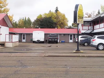 a building with a truck and a trailer in a parking lot at Viking Lamplighter Motel in Viking