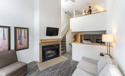 a living room with a couch and a fireplace at Mountain Side Hotel Whistler by Executive in Whistler