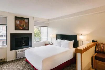 a hotel room with a large bed and a fireplace at Mountain Side Hotel Whistler by Executive in Whistler