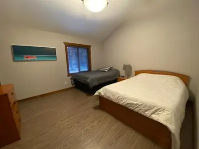 a bedroom with a bed and a ottoman in it at Wolf Den in Valemount