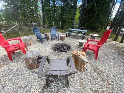 a group of chairs sitting around a fire pit at Wolf Den in Valemount