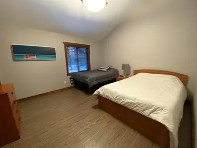 a bedroom with a bed and a ottoman in it at Wolf Den in Valemount