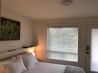 a bedroom with a window and a bed with white pillows at Sounds of the Sea in Ucluelet