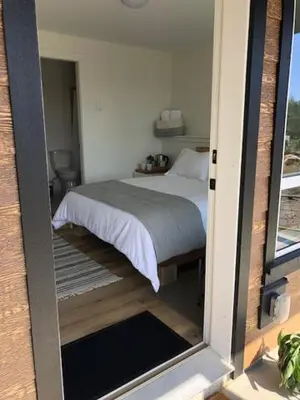 a bedroom with a bed in a room with a window at Sounds of the Sea in Ucluelet