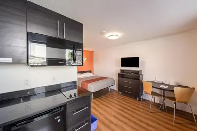 a hotel room with a bed and a desk and a bedroom at Motel 6-Cranbrook, BC in Cranbrook