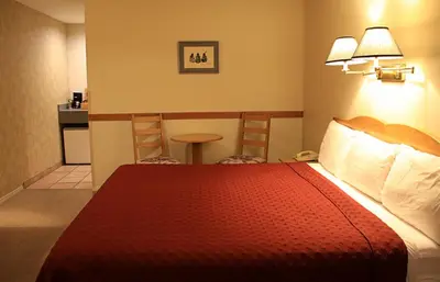 a hotel room with a bed and a small table at Cariboo Lodge in Clinton