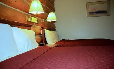 a hotel room with a bed and two lamps at Cariboo Lodge in Clinton