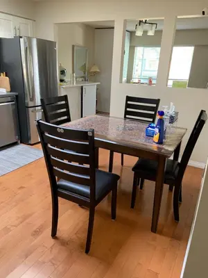 a dining room table with chairs and a kitchen at Orchid House near Vancouver YVR Airport in Richmond