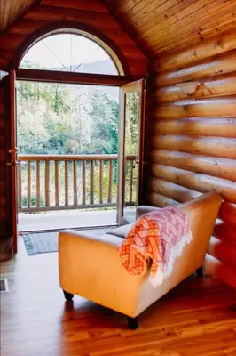 a couch in a room with a large window at Cowichan River Lodge in Lake Cowichan