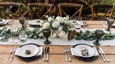 a table with plates and silverware and flowers on it at Cowichan River Lodge in Lake Cowichan