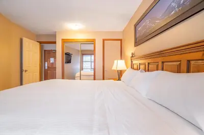 a large white bed in a room with a window at #433 The Aspens On Blackcomb in Whistler