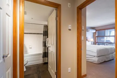 a bedroom with a bed and a bathroom with a tub at #433 The Aspens On Blackcomb in Whistler