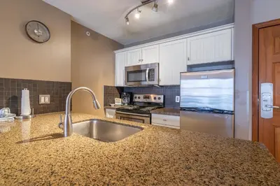 a kitchen with a sink and a stainless steel refrigerator at #433 The Aspens On Blackcomb in Whistler