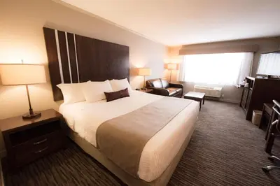 a hotel room with a large bed and a chair at Best Western Mountainview Inn in Golden