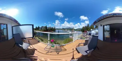 a deck with chairs and a table on a house at Bayshore Waterfront Inn in Ucluelet