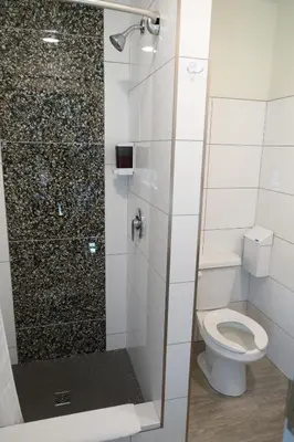 a bathroom with a shower with a toilet at Canmore Downtown Hostel in Canmore