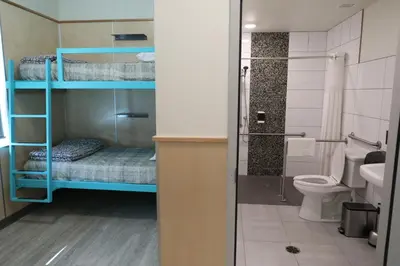a bathroom with two bunk beds and a toilet at Canmore Downtown Hostel in Canmore