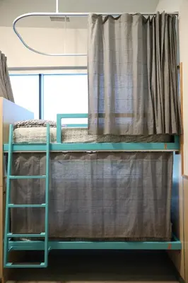 a bunk bed in a room with a window at Canmore Downtown Hostel in Canmore