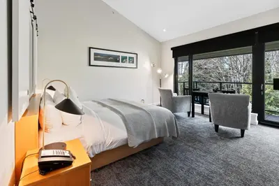 a bedroom with a bed and a desk with a telephone at Black Rock Oceanfront Resort in Ucluelet