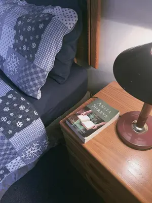 a bed with a lamp and a book on a table at Alpine Meadows Lodge in Golden