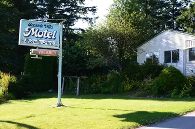 a motel sign in front of a house at Seaside Villa Motel & RV Park in Powell River