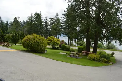 a park with picnic tables and trees on the grass at Seaside Villa Motel & RV Park in Powell River
