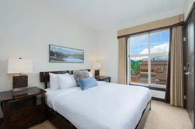 a bedroom with a large white bed and a window at Heavenly Mountain Condo managed by Little Sister Getaways in Canmore