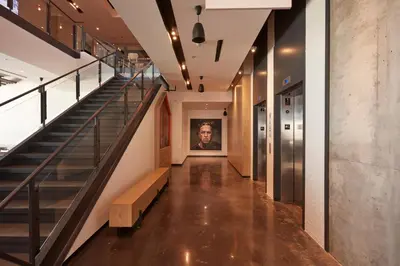a hallway with stairs and a painting of a man at Alt Hotel Calgary East Village in Calgary