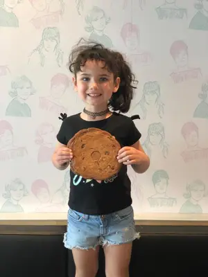 a little girl is holding a baseball glove at Alt Hotel Calgary East Village in Calgary