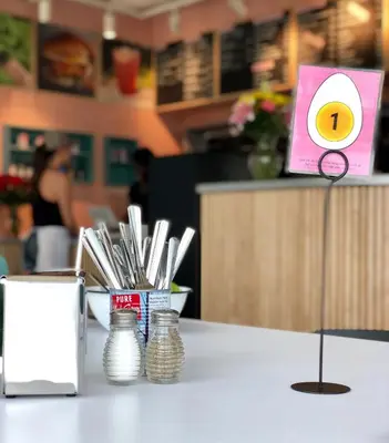 a table in a restaurant with a menu and chopsticks at Alt Hotel Calgary East Village in Calgary