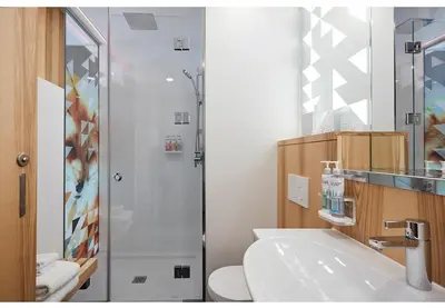 a bathroom with a shower and a toilet and a sink at Alt Hotel Calgary East Village in Calgary