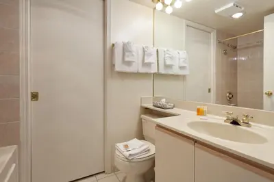 a white bathroom with a sink and a toilet at The Marquise by Whistler Premier in Whistler