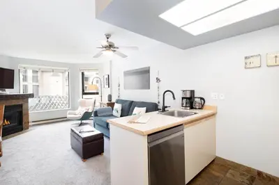 a kitchen with a sink and a living room at The Marquise by Whistler Premier in Whistler