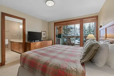 a bedroom with a bed and a television and a tub at Montebello by Whistler Premier in Whistler