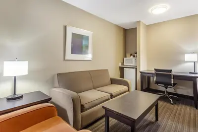 a living room with a couch and a desk at Best Western Cold Lake Inn in Cold Lake