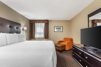 a hotel room with a bed and a flat screen tv at Best Western Cold Lake Inn in Cold Lake