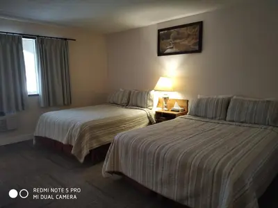 a hotel room with two beds and a window at Pleasant Valley Motel Houston in Houston