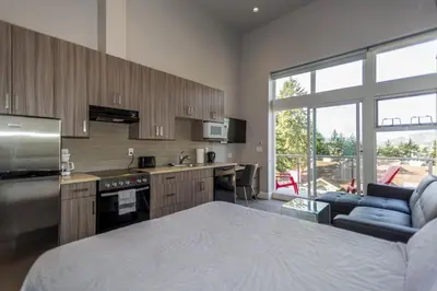 a kitchen with a bed and a living room at SoLo Suites in Victoria