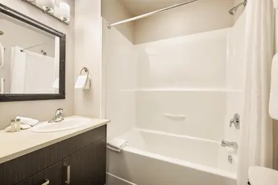 a bathroom with a tub and a sink and a bath tub at SoLo Suites in Victoria