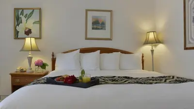a hotel room with a bed with a tray of food on it at Valley Star Motel in Penticton