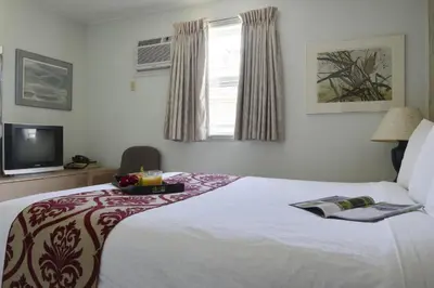 a bedroom with a bed with a tray of food on it at Valley Star Motel in Penticton