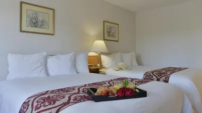 a hotel room with two beds with a tray of fruit at Valley Star Motel in Penticton