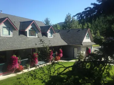 a house with pink flowers in front of it at Eagle's Nest B&B in Lake Country