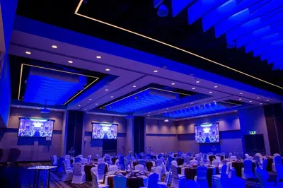 a banquet hall with tables and chairs and blue lighting at Holiday Inn Edmonton South - Evario Events by IHG in Edmonton